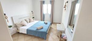 a small bedroom with a bed with a blue blanket at Sunset house Cabo Verde in Santa Maria