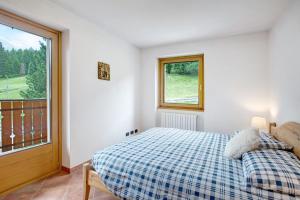 una camera con letto e finestra di Casa Michela Trilocale a Valfurva