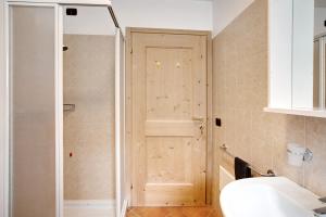 bagno con doccia e porta in legno di Casa Michela Trilocale a Valfurva