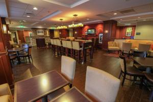 a restaurant with tables and chairs and a bar at Hampton Inn Lincolnton in Lincolnton