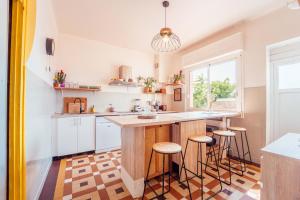 a kitchen with a large island with stools at La Boga L'Auberge à l'ambiance Surf à Biscarrosse Plage in Biscarrosse-Plage