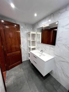 a white bathroom with a sink and a mirror at The Sallies - 3 bedroom villa with private pool in Tías