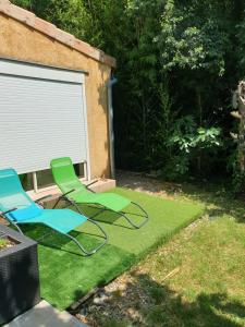 zwei Gartenstühle auf dem Rasen im Garten in der Unterkunft Maison proche rivière in Ruoms