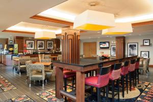 a restaurant with a bar with red chairs at Hampton Inn Columbus/Taylorsville in Edinburgh