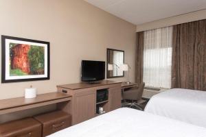 a hotel room with a bed and a desk with a television at Hampton Inn Seymour in Seymour