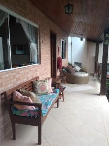 a patio with two benches and a window at Ilhabela Casa Família Feliz in Ilhabela