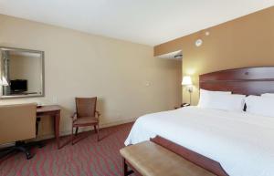 um quarto de hotel com uma cama grande e uma secretária em Hampton Inn & Suites Port Richey em Port Richey