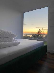 a bedroom with a bed with a large window at Domek nad jeziorem in Kruklanki