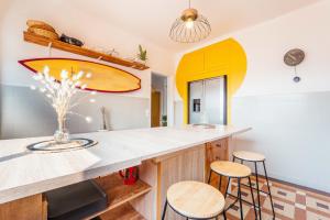 a kitchen with a surfboard on the wall at La Boga L'Auberge à l'ambiance Surf à Biscarrosse Plage in Biscarrosse-Plage