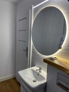 a bathroom with a sink and a mirror at Domek nad jeziorem in Kruklanki