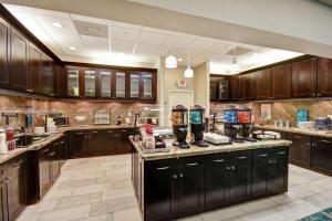 een grote keuken met donkerhouten kasten en apparaten bij Homewood Suites by Hilton Tampa-Port Richey in Port Richey