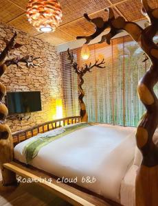 um quarto com uma cama feita de uma árvore em Roaming Cloud Sun Moon Lake B&B em Yuchi