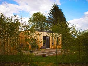 een klein gebouw met een deur in een tuin bij Casita Colombia - Glamping v Brdech - Příbram 