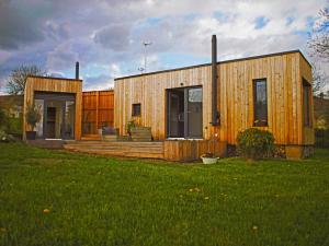 a small wooden house with a green lawn at Casita Colombia - Glamping v Brdech - Příbram 