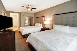 a hotel room with two beds and a flat screen tv at Homewood Suites by Hilton Tampa-Port Richey in Port Richey