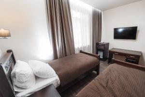 Habitación de hotel con cama y TV en Dvin Hotel, en Pavlodar