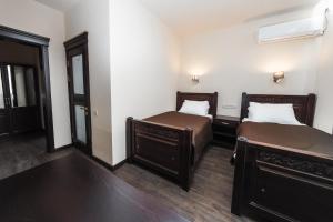 1 dormitorio con 2 camas y ventana en Dvin Hotel, en Pavlodar