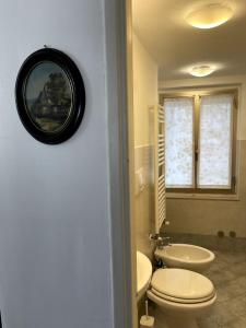 un bagno con un water bianco e un lavandino di Attico con terrazzo panoramico a 200 mt dal Duomo a Perugia Altre 26 foto