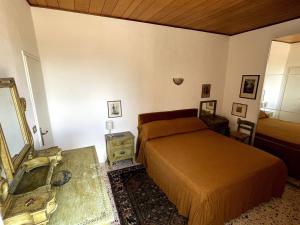 una camera da letto con un letto, un tavolo e uno specchio di Attico con terrazzo panoramico a 200 mt dal Duomo a Perugia