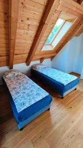 two beds in a room with wooden ceilings at Górska Ostoja in Sieniawa