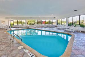 a pool in a hotel with tables and chairs at Hampton Inn Columbus/Delaware I-71 North in Sunbury