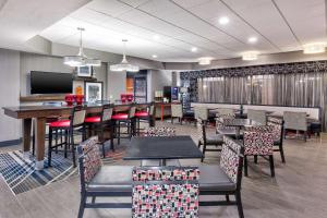 a dining room with tables and chairs and a television at Hampton Inn Columbus/Delaware I-71 North in Sunbury