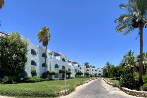 Azure Retreat - Private Luxury Sea View Apartment في شرم الشيخ: المنظر الخارجي لمنتجع به نخيل