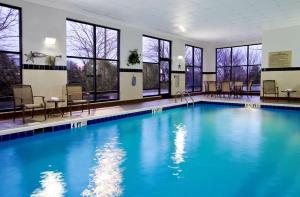 una piscina con agua azul en un edificio con ventanas en Hampton Inn & Suites Columbus Hilliard, en Hilliard