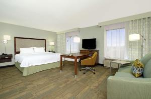 Habitación de hotel con cama, escritorio y TV. en Hampton Inn & Suites Columbus Hilliard, en Hilliard