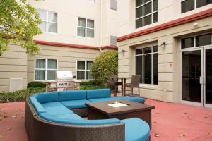 un patio con divano blu, tavolo e edificio di Homewood Suites Columbus - Airport a Columbus