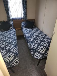 a room with two beds and a window at Let's Caravan at Whitley Bay in Whitley Bay