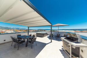 a patio with a grill and a table and chairs at Rooftop New Castel 2023 in Kaštela