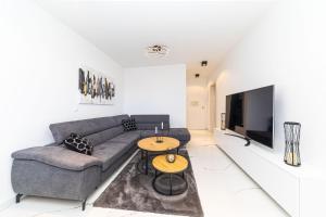 salon z kanapą i telewizorem w obiekcie Rooftop New Castel 2023 w mieście Kaštela