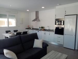 a living room with a couch and a kitchen at Villa María in Alicante