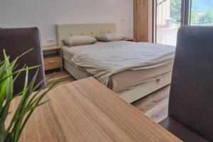 een slaapkamer met een bed, een bureau en een tafel bij Apartmani Tvins in Soko Banja