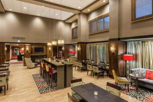 a lobby with tables and chairs and a bar at Hampton Inn & Suites Columbus Polaris in Columbus