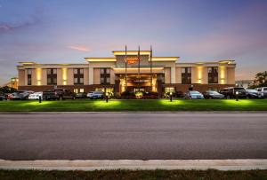 un gran edificio con coches estacionados en un estacionamiento en Hampton Inn West, en Columbus