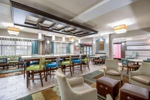 a restaurant with tables and chairs and a bar at Hampton Inn West in Columbus