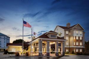 un hotel con una bandera americana delante de él en Homewood Suites Champaign-Urbana, en Champaign