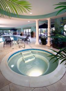 una piscina en un edificio con mesa y sillas en Hampton Inn & Suites Columbus Polaris, en Columbus