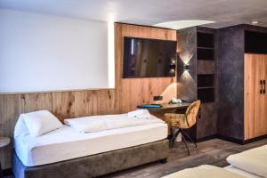 Schlafzimmer mit einem Bett, einem Schreibtisch und einem Tisch in der Unterkunft Hotel Grieserhof in Lermoos