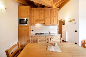 een keuken met houten kasten en een houten tafel bij Casa Michela Trilocale Mansardato in Valfurva