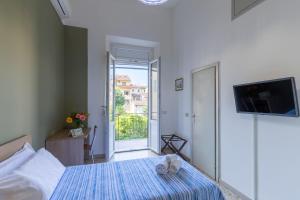 a bedroom with a bed with a tv and a window at Antica Dimora Sant'Anna in Florence