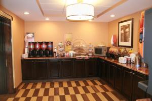 a kitchen with black cabinets and a checkered floor at Hampton Inn Long Island/Commack in Commack