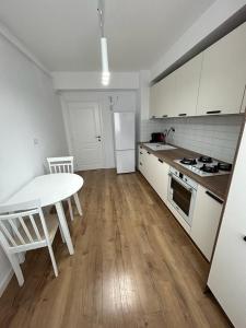 a kitchen with a table and a white table and a table and a kitchen with at Lovely Cozy Apartments in Central Suceava in Suceava +14 photos