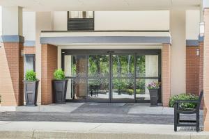 eine Glastür eines Gebäudes mit Topfpflanzen in der Unterkunft Hampton Inn Commerce in Commerce