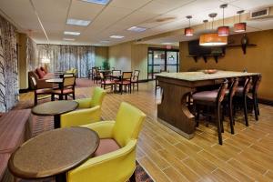 a lobby with tables and chairs and a bar at Hampton Inn Commerce in Commerce