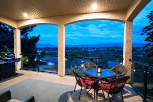 a patio with a table and chairs on a balcony at Sunrise Valley Suite in West Kelowna
