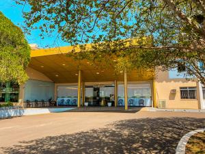 a building with a yellow roof with tables and chairs at Hotel Monalisa in Foz do Iguaçu