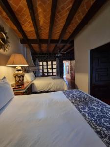 a bedroom with two beds and a lamp on a table at Hacienda de las Flores in San Miguel de Allende